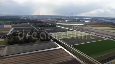 4k空中视频<strong>城际列车</strong>穿越荷兰农业景观与五颜六色的郁金香田野春天